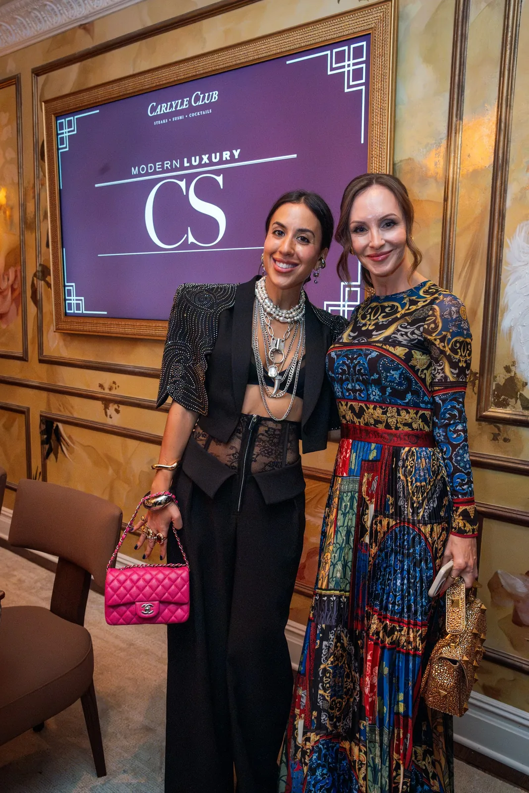 Two guests in front of the Modern Luxury CS screen