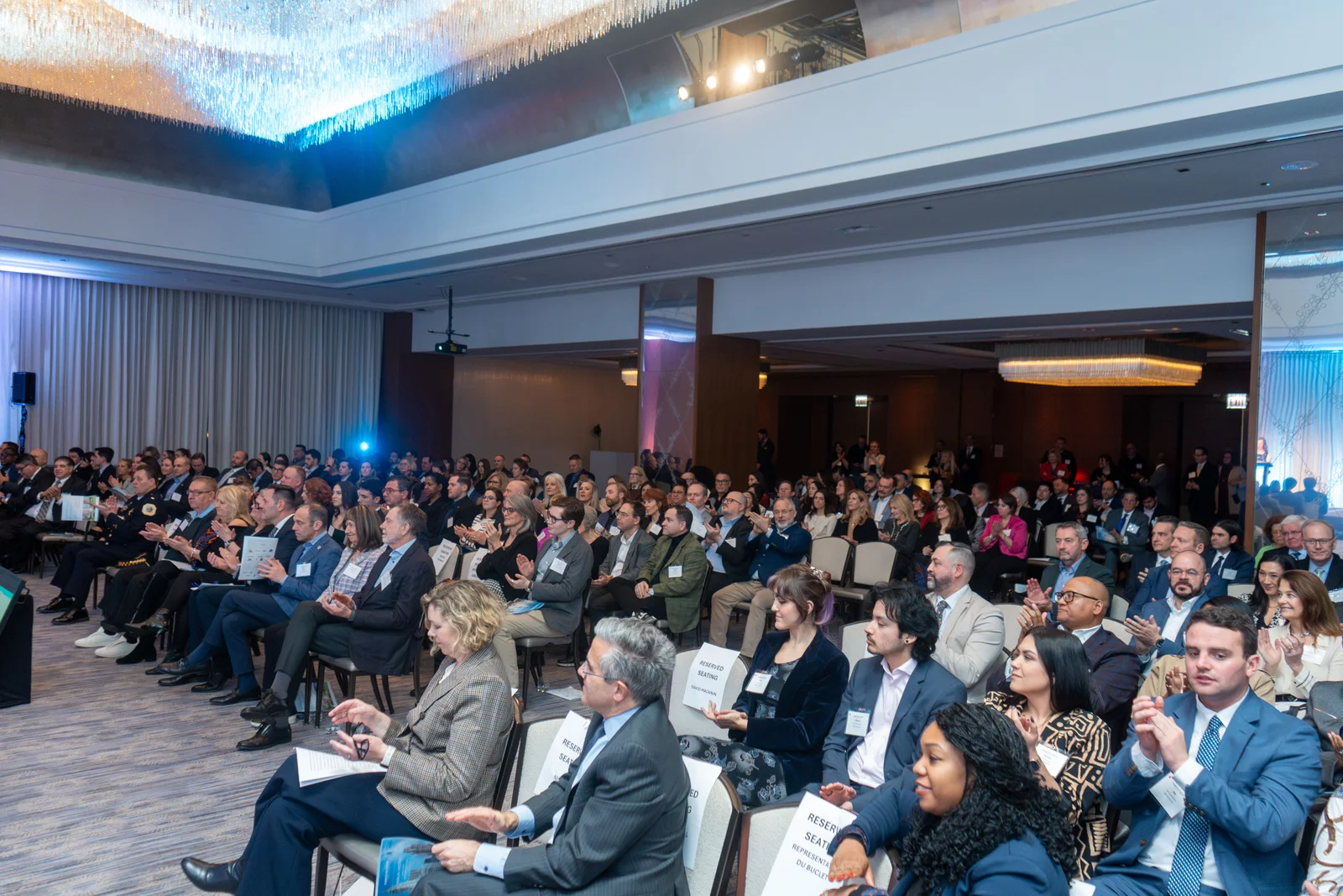 Full ballroom at a Magnificent Mile Association program, audience under a chandelier